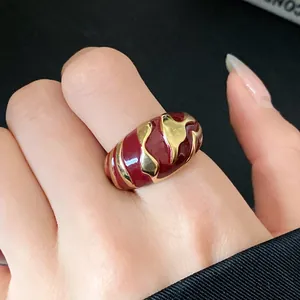 Nahaufnahme eines Vintage-Rings aus roter Emaille mit unregelmäßigen Goldmustern für Damen