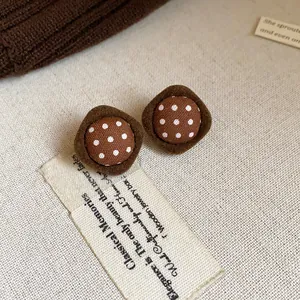 Close-up detail of vintage brown polka dot fabric stud earrings with a soft flocked border