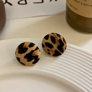 Primer plano detallado de la textura de pendientes de botón con estampado de leopardo