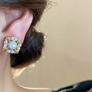 Nahaufnahme eleganter 18k vergoldeter Perlen- und Zirkon-Irisblüten-Clip-Ohrring.