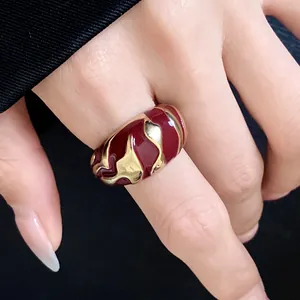 Nahaufnahme eines goldenen Vintage-Rings mit unregelmäßigem rotem Emaille-Muster