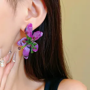 Macro di orecchini vintage a fiore in cristallo viola indossati da una modella asiatica