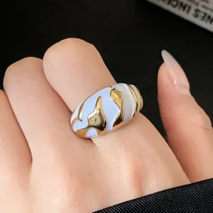 Nahaufnahme eines Vintage-Emaillerings mit unregelmäßigen Wellen in Blau und Gold