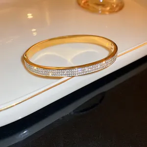 Close-up detail of a light luxury gold-colored bangle inlaid with shimmering zircon stones