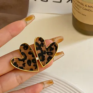 Primer plano de pendientes de corazón con estampado de leopardo y bordes dorados chic.