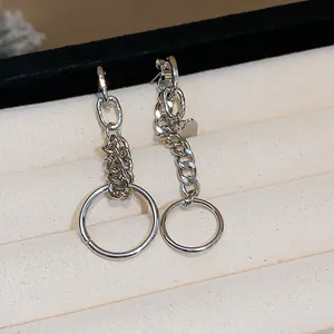Primer plano de pendientes asimétricos de cadena de plata con corazón y aro