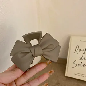 Nahaufnahme einer matt milch-teebraunen Schleifen-Haarklammer mit elegantem Design