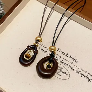 Vue détaillée d'un collier pendentif en résine avec une perle naturelle œil de tigre