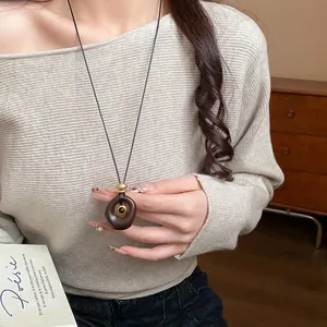 Détail macro d'un élégant collier en résine ovale avec une pierre d'oeil de tigre polie