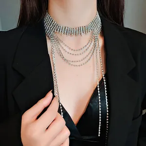 Dettaglio di una collana a frange multistrato con strass argentati indossata con un blazer nero
