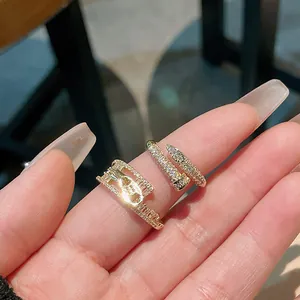 Detailed macro shot of elegant zircon-encrusted snake and geometric open gold rings