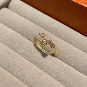 Detailed view of a golden snake-shaped open ring encrusted with sparkling zircons