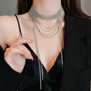 Dettaglio di un elegante girocollo multistrato con nappe in strass indossato da una modella