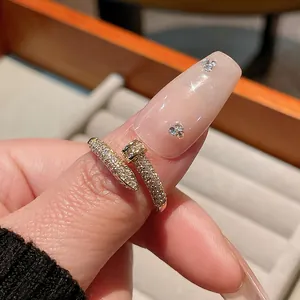 Close-up of gold-plated nail ring with pavé zircons for a luxury aesthetic look.