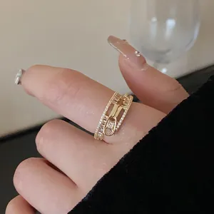 Elegant gold-plated zipper design ring with sparkling zircons, close-up on a hand