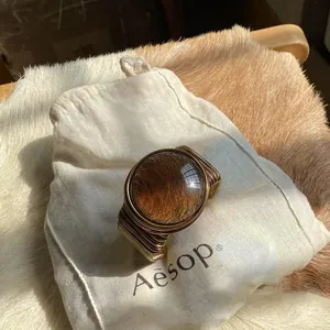 Macro view of vintage gold wire-wrapped open bracelet featuring a large amber glass dome