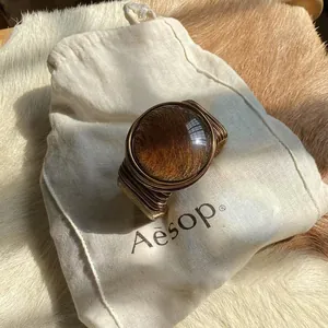 Detailed view of a twisted wire-wrapped cuff bracelet with a golden glass dome