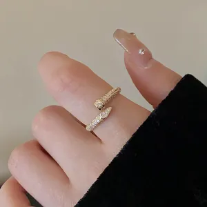 Macro view of a gold-plated snake-shaped open ring encrusted with sparkling zircons.