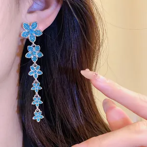 Close-up of elegant long blue flower tassel earrings featuring zircon inlay and silver pins