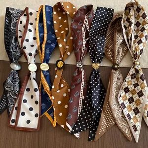Dettaglio di sciarpe in stile vintage con vari motivi e anelli metallici decorativi
