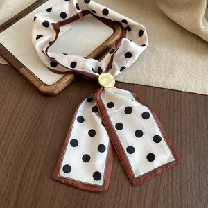 Dettaglio della collana sciarpa di seta a pois retrò con fibbia in metallo dorato opaco