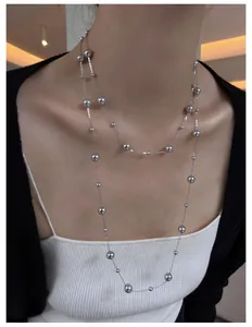 Close-up detail of an elegant double-layered silver beaded necklace on a model's neck