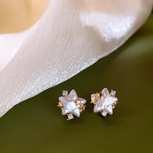 Close-up view of elegant star-shaped pearl stud earrings with gold star accents