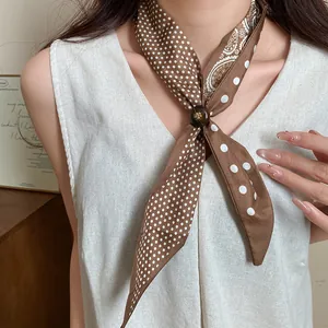 Dettaglio di una collana a foulard retrò a pois con fibbia decorativa in legno.