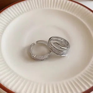 Detailed macro shot of two silver-plated open rings with shimmering zircon accents