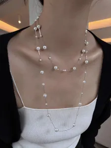 Elegant multi-layered pearl long necklace worn by model, showing vintage french style.