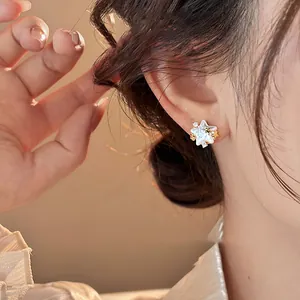 Close-up detail of a refined star-shaped stud earring featuring white shell texture