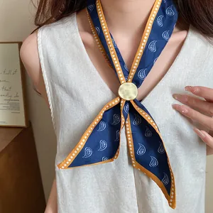Dettaglio ravvicinato di una collana a sciarpa paisley blu con fibbia dorata rotonda