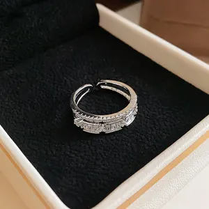 Close-up of open silver ring with baguette cubic zirconia in a black velvet jewelry box.