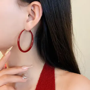 Elegant close-up view of a retro red spray-painted hoop earring worn by an Asian model