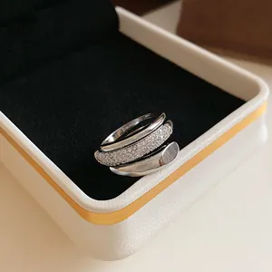 Detailed macro shot of a multi-layer silver open ring with sparkling zircon in a velvet box