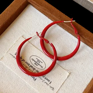 Macro detail of vibrant red spray-painted retro hoop earrings with 925 silver needles