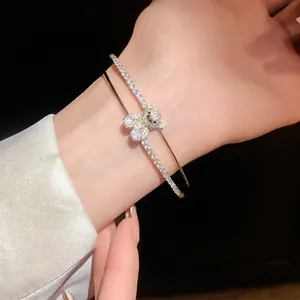 Eleganter doppellagiger Armreif mit glitzerndem Zirkonia-Bär-Anhänger am Handgelenk.