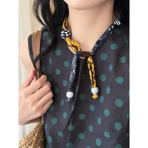 Close-up of a stylish Korean fabric necklace featuring patterned cloth and beads on a model