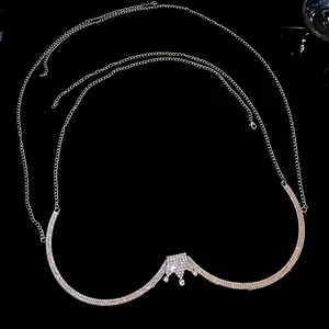 Detail of the elegant silver body chain featuring a sparkling rhinestone crown pendant