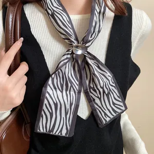 Primo piano di una collana vintage in seta con stampa zebrata e fibbia in metallo argento.