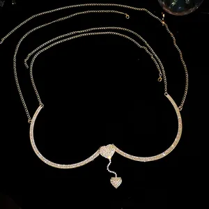 Macro detail of rhinestone heart pendant and sparkling golden metallic chest chain