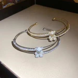 Detailaufnahme luxuriöser zweilagiger Zirkonia-Bären-Armreifen in Gold- und Silberschliff