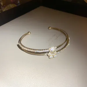 Nahaufnahme eines goldenen doppelreihigen Armreifs mit einem funkelnden Zirkon-Bären