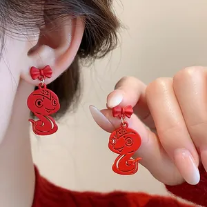 Close-up detail of festive red snake earrings with elegant bow for the Year of the Snake
