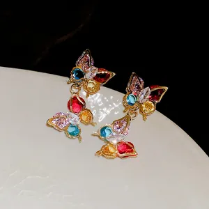 Detailed close-up view of colorful zircon butterfly earrings with vibrant sparkling stones