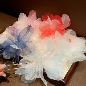 Close-up detail of vintage chiffon flower hairpins with delicate pearl tassels.