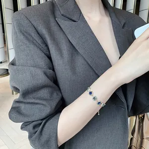 Close-up of elegant gold-plated bracelet with blue and clear crystals on wrist