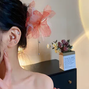 Detail of chiffon flower hairpin with pearl tassel worn on elegant updo hairstyle
