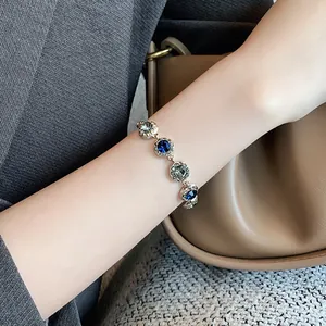 Close-up of elegant gold-plated bracelet with blue and grey crystals on wrist