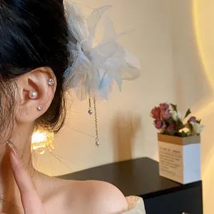 Detail view of an elegant chiffon flower hairpin with hanging pearl tassels in hair